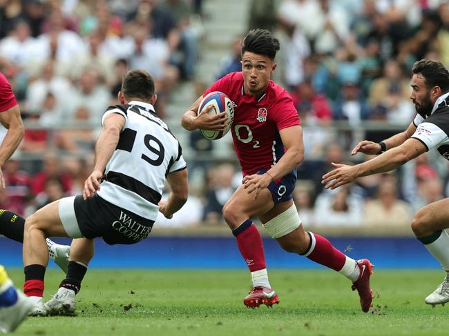 Marcus Smith of England runs with the ball during the International match between England and Barbarians at Twickenham Stadium.