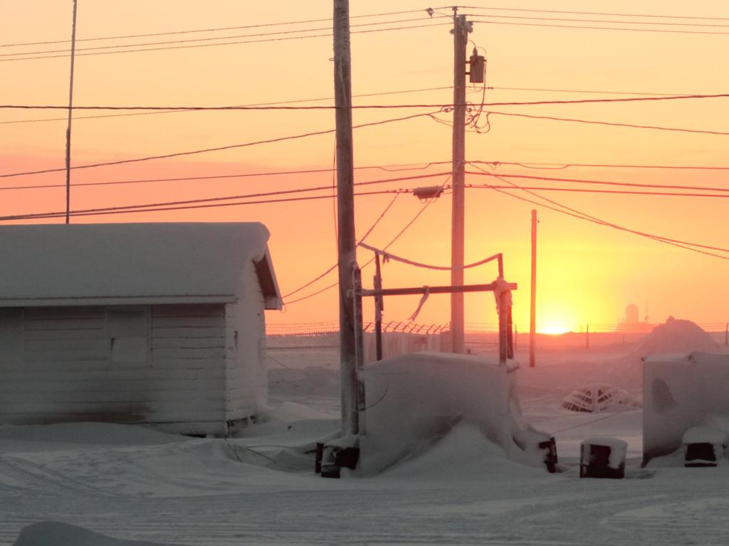 C0KRNB First sunrise in 84 days in Barrow, AK in the Arctic Circle looking past some civilian homes with the airfield in the background, Utqiagvik  Picture: Alamy