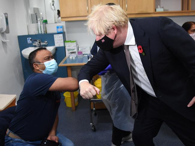 Britain's Prime Minister Boris Johnson greets a man receiving a Covid booster vaccine in London. Picture: AFP