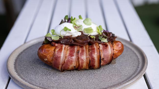 The knackwurst sausage wrapped in bacon with cheddar hash brown, onion jam and poached eggs. Picture: David Kelly.