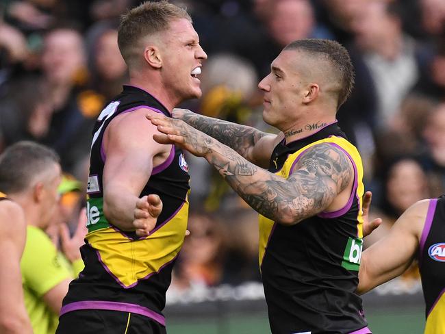 Josh Caddy (left) and Dustin Martin (centre right) of the Tigers react after Caddy kicked a goal during the Round 20 AFL match between the Richmond Tigers and the Hawthorn Hawks at the MCG in Melbourne, Sunday, August 6 , 2017. (AAP Image/Julian Smith) NO ARCHIVING, EDITORIAL USE ONLY