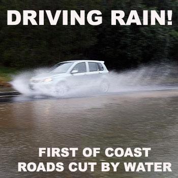 A small car cars drives through flood waters on Chevallum Road this morning. Gale force winds and more than 75mm of rain overnight have caused some minor flooding on the Coast. Photo: Jason Dougherty