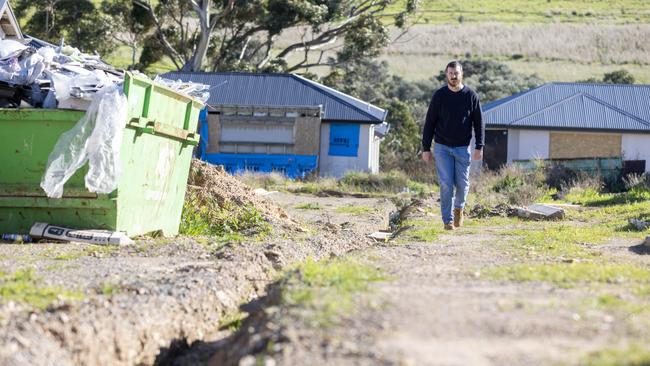 Edward Gilmore with his unfinished home after the collapse of the Felmeri Group in O'Halloran Hill, before the road was completed. Picture: Kelly Barnes