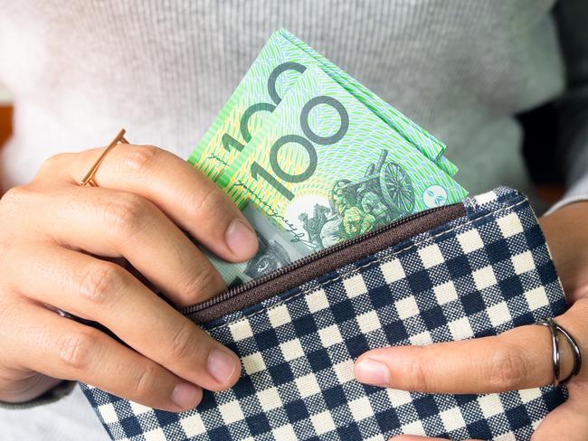 Woman put dollar australia money into wallet.