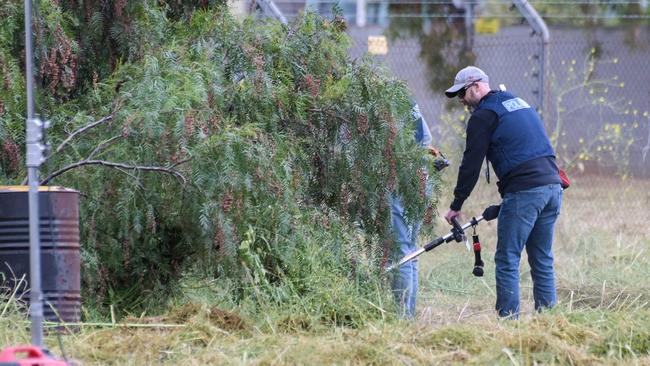 Police cut back bushes and trees at the rear of a vacant paddock in Salisbury South, where a decomposed body was found on Tuesday. Picture: Brenton Edwards