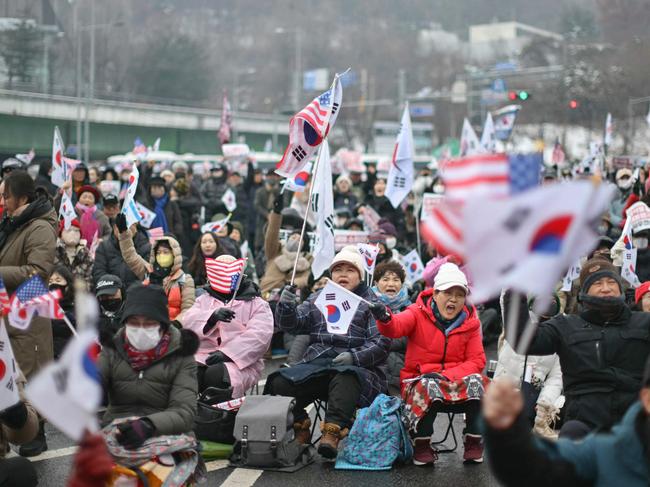 Thousands of South Korean protesters braved a snowstorm on Sunday. Picture: Anthony Wallace/AFP