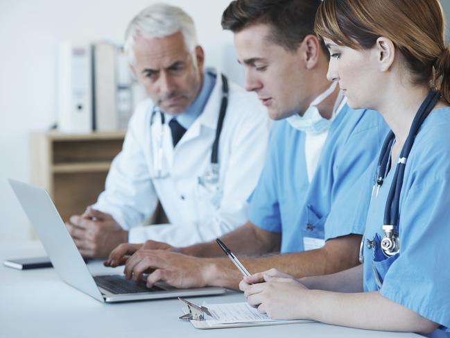 A group of doctors discussing information displayed on a laptop