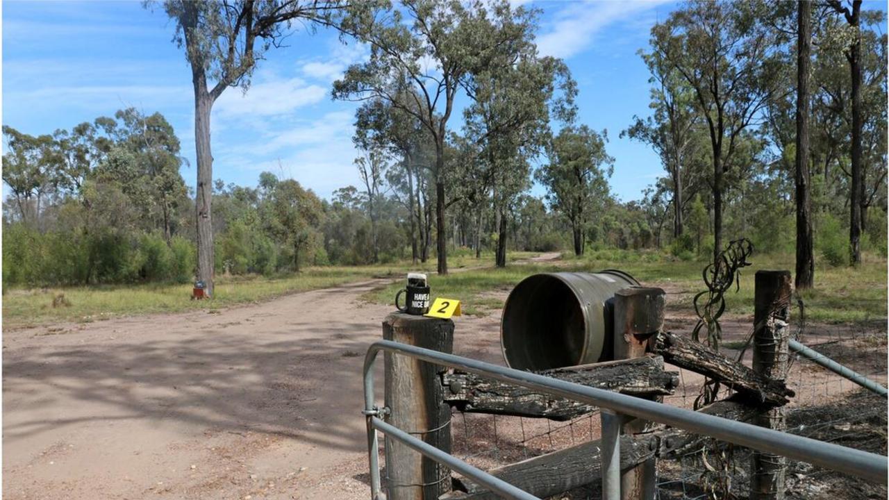 An evidence marker on top of a fence post at the front of the Train property where a smashed mobile phone sits in a mug.