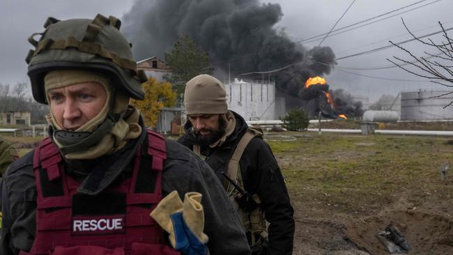 A Ukrainian rescue service member and a soldier inspect damage to an oil reserve in Kherson. Picture: AFP