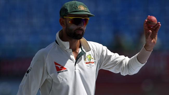 Nathan Lyon shows the ball as he celebrates his five-wicket haul against India.