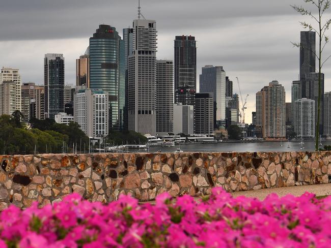 A man is seen walking his dog at the Kangaroo Point cliffs as storm clouds gather over the Brisbane CBD on Friday, March 15, 2019. South-East Queensland has had a record-breaking March heatwave with Brisbane peaking at 37.7C on March the 12th, its hottest March day since 2007. (AAP Image/Darren England) NO ARCHIVING