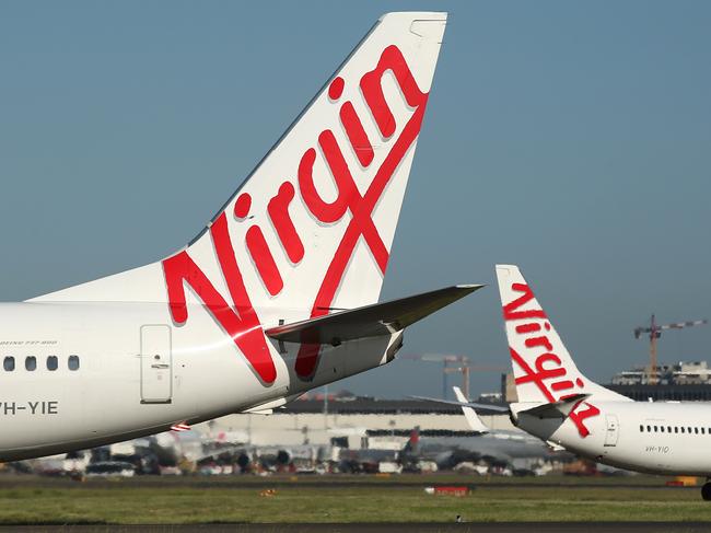 The Virgin Australia Holdings Ltd. logo is displayed on the tails of a Boeing Co. 737-800, left, and a Boeing Co. 737-8FE aircraft preparing to take off at Sydney Airport in Sydney, Australia, on Monday, Feb. 8, 2016. Virgin Australia is scheduled to announce half-year earnings on Feb. 11. Photographer: Brendon Thorne/Bloomberg