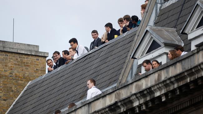 People watch the procession from a roof overlooking the route. Picture: Getty Images.