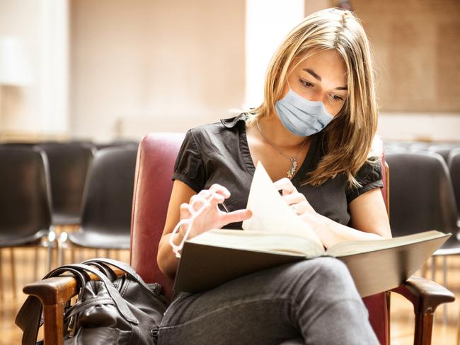 student with face mask in the library