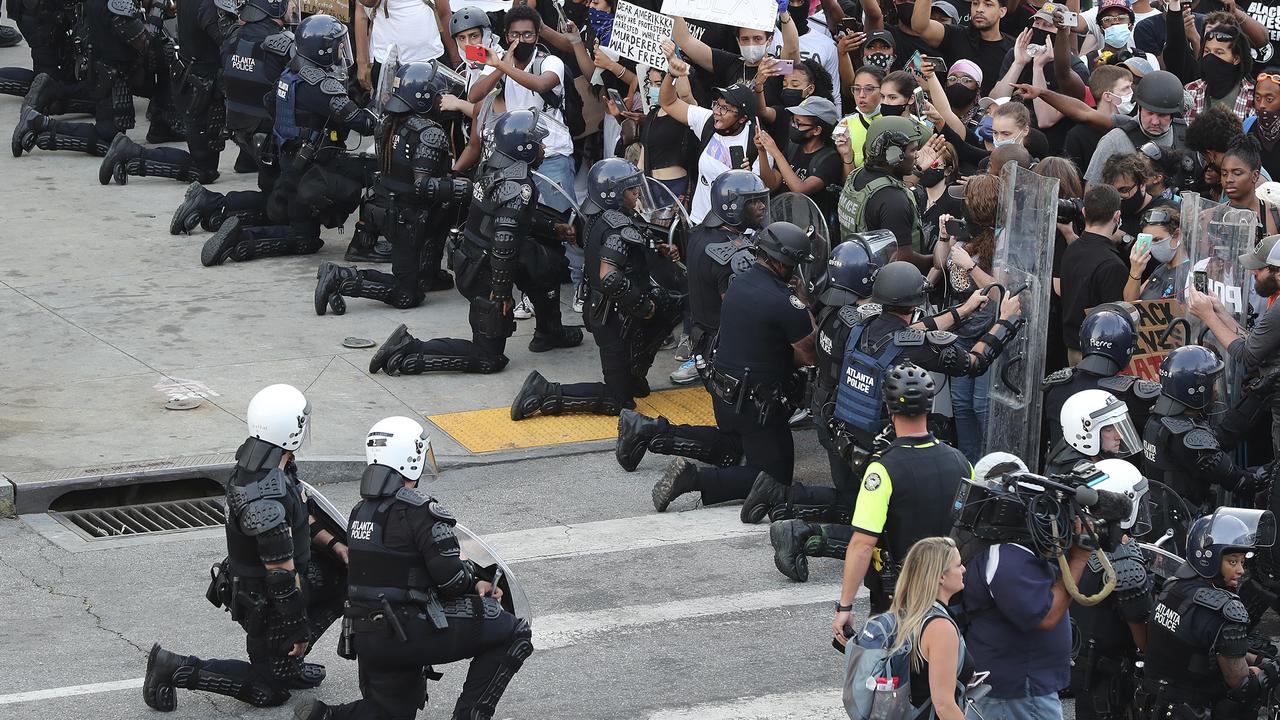 Police have taken a knee at protests from coast to coast. Picture: Curtis Compton/Atlanta Journal-Constitution via AP)