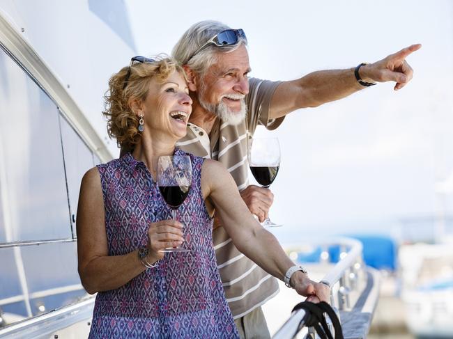 Happy senior couple enjoying wine on yacht. seniors and retirees travel, holidays, generic