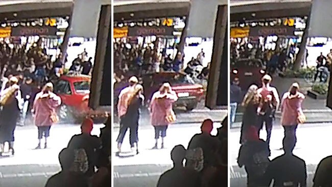 Pedestrians scramble to get clear of the car as it mounts the Swanston St footpath.