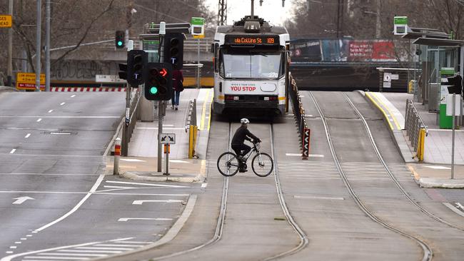 A person crosses an empty street in Melbourne as the city endures its sixth lockdown. Picture: AFP