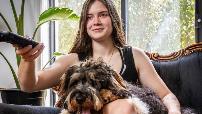 Jade Williams watches TV with her dog Western. Picture: Jake Nowakowski