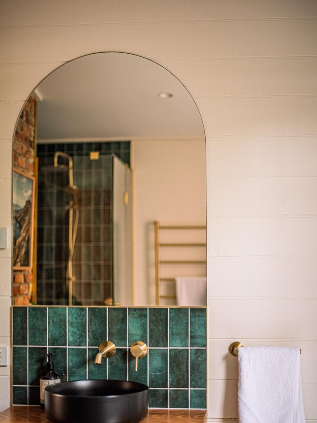 Jade green hand-shaped tiles help to create a lush oasis-feel to the bathroom. Picture: Em Godfrey