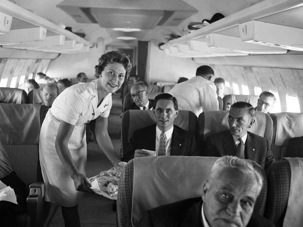 An air stewardess serving food to passengers on board a Qantas Boeing 707 plane at London in 1959. Picture: Daily Herald/Mirrorpix/Mirrorpix via Getty Images