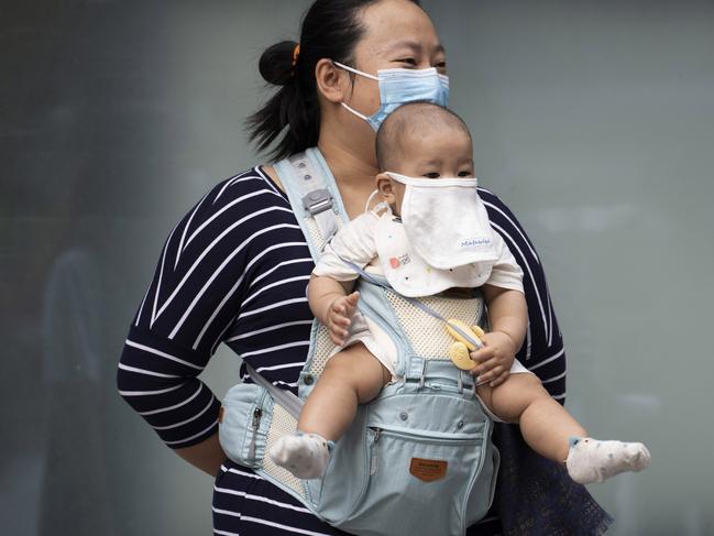 A woman and child wearing masks to help protect against the coronavirus on the streets of Beijing. Picture: AP