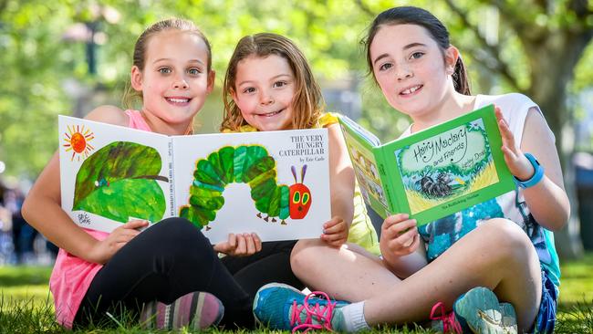 Casey Boyd, 9, Madison Boyd, 4 and Tia Dempsey, 9 read The Very Hungry Caterpillar and Hair Maclary. Picture: Jake Nowakowski