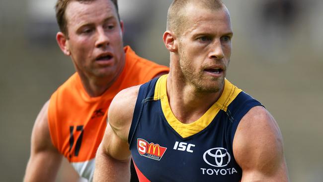 Crows legend Scott Thompson streams away from GWS star Steve Johnson in a scratch match at Football Park last week. Picture: Daniel Kalisz/Getty Images