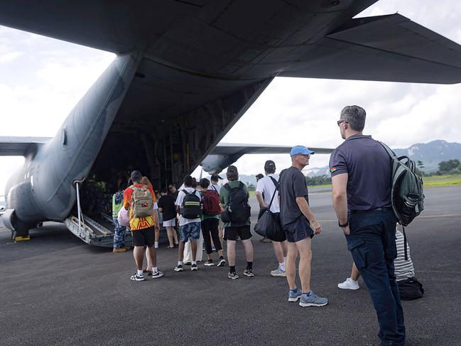 This handout photo taken and released on December 20, 2024 by the Australian Department of Foreign Affairs and Trade (DFAT) shows people boarding a Royal Australian Air Force plane after an earthquake struck Port Vila, the capital city of Vanuatu. Overseas rescuers joined a hunt for survivors in the rubble of shattered buildings in earthquake-rocked Vanuatu, with officials saying the toll of nine dead is set to rise. (Photo by Handout / AUSTRALIAN DEPARTMENT OF FOREIGN AFFAIRS AND TRADE / AFP) / RESTRICTED TO EDITORIAL USE - MANDATORY CREDIT 