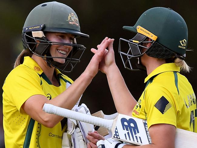 Australia's Ellyse Perry (L) and captain Meg Lanning (R) celebrate as Australia defeats England in the women's one-day international cricket match between Australia and England in Melbourne on February 8, 2022. (Photo by William WEST / AFP) / -- IMAGE RESTRICTED TO EDITORIAL USE - STRICTLY NO COMMERCIAL USE --