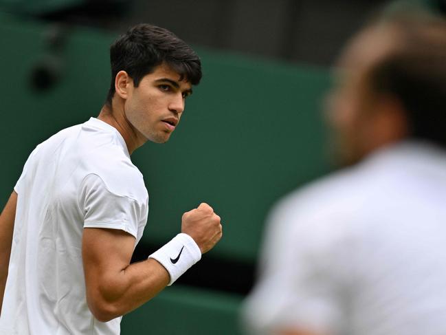 TOPSHOT - Spain's Carlos Alcaraz reacts after scoring a point against Russia's Daniil Medvedev during their men's singles semi-final tennis match on the twelfth day of the 2024 Wimbledon Championships at The All England Lawn Tennis and Croquet Club in Wimbledon, southwest London, on July 12, 2024. (Photo by ANDREJ ISAKOVIC / AFP) / RESTRICTED TO EDITORIAL USE