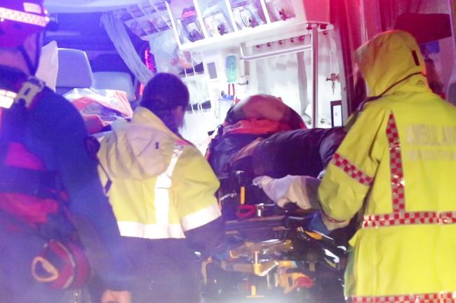 SES crews rescue a person bitten by snake whilst attempting to rescue a man during floods at Auld Avenue in Milperra. Picture: TNV