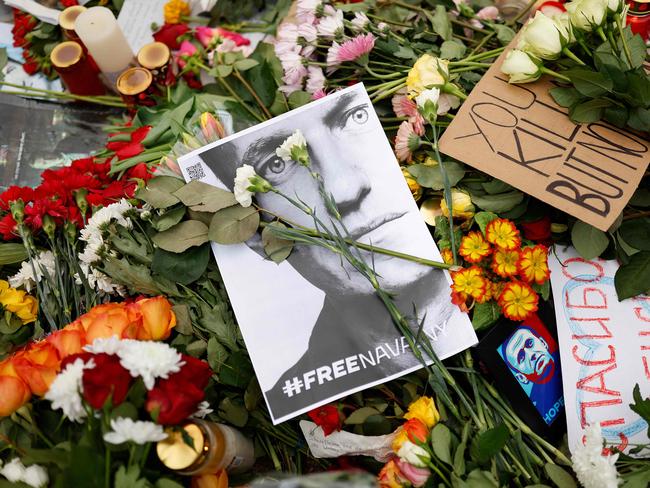 People lay flowers and candles at a memorial on February 18, 2024 in front of the Russian embassy in Berlin, following the death of the Kremlin's most prominent critic Alexei Navalny in an Arctic prison. Navalny's death after three years in detention and a poisoning which he blamed on the Kremlin deprives Russia's opposition of its figurehead at time of intense repression and Moscow's campaign in Ukraine. (Photo by Odd ANDERSEN / AFP)