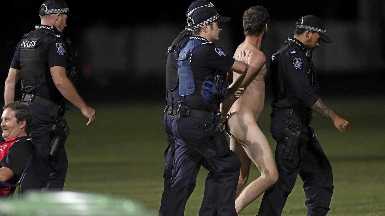  A streaker is lead away by police during the 2019 JLT Community Series AFL match between the Gold Coast Suns and the Western Bulldogs at Great Barrier Reef Arena on Sunday in Mackay. Picture: Ian Hitchcock