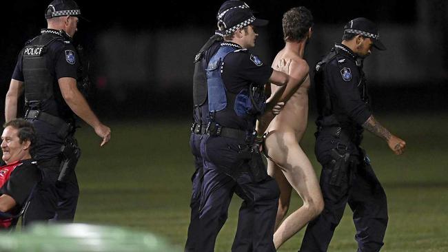 A streaker is lead away by police during the 2019 JLT Community Series AFL match between the Gold Coast Suns and the Western Bulldogs at Great Barrier Reef Arena on Sunday in Mackay. Picture: Ian Hitchcock