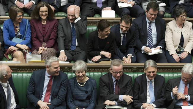 Theresa May, first row centre, laughs during the Brexit debate this morning. Picture: AP.