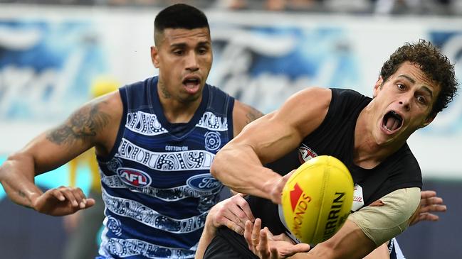 Ed Curnow handballs under pressure from Tim Kelly before he was rested in the second half. Picture: AAP Image/Julian Smith.