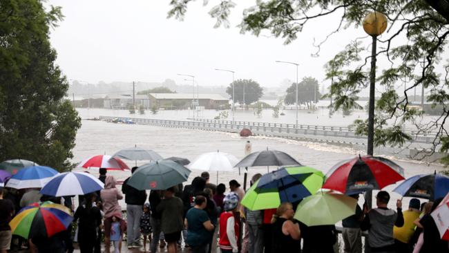 A crowd gathers at the Hawkesbury River, which is expected to reach very high levels on Monday. Picture: Damian Shaw