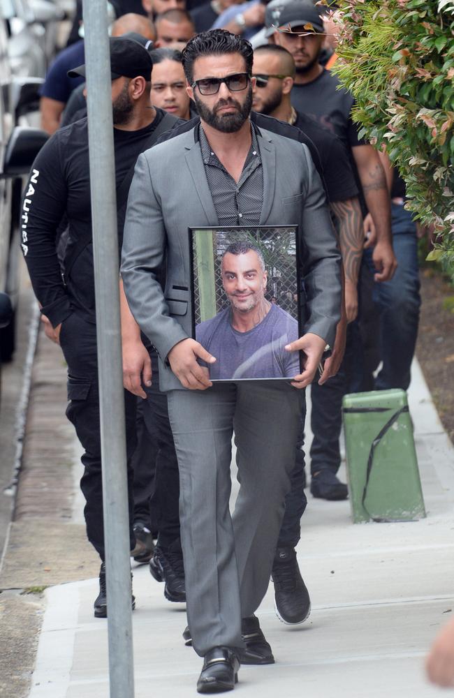 Mourners with a framed photo of Mahmoud Hawi yesterday. Picture: Jeremy Piper