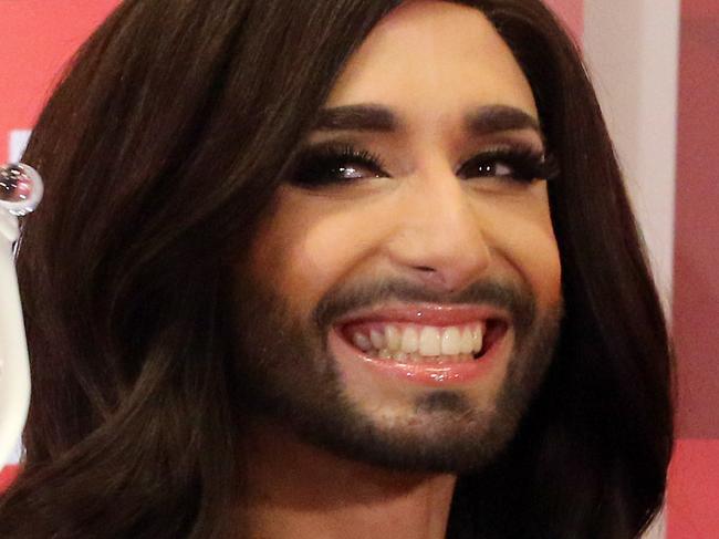 Austrian singer Conchita Wurst arrives with the trophy at the airport in Vienna Sunday May 11, 2014. Bearded drag queen Conchita Wurst has made a triumphant return to Austria after winning the Eurovision Song Contest in Copenhagen Saturday, in what the country's president called a victory for tolerance in Europe. (AP Photo/Ronald Zak)