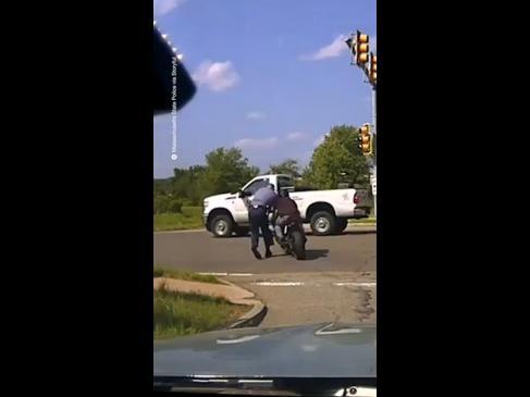 Biker pushes police into traffic