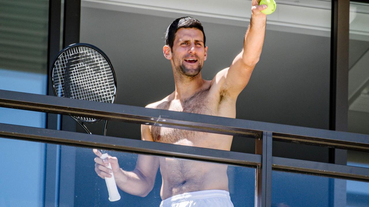Men's world number one tennis player Novak Djokovic of Serbia waves to fans from a hotel balcony in Adelaide, South Australia on January 20, 2021, one of the locations where players have quarantined for two weeks upon their arrival ahead of the Australian Open tennis tournament in Melbourne. (Photo by Morgan SETTE / AFP)