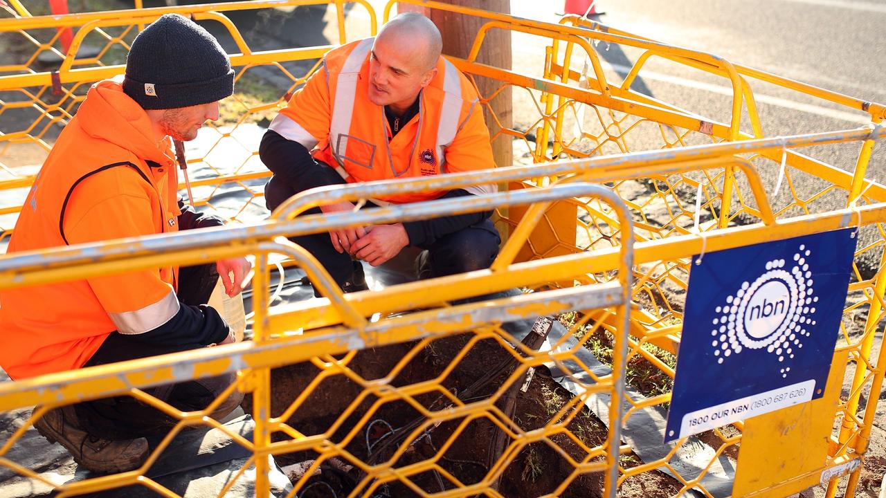 NBN workers at a streetside pit. Picture: NBN Co