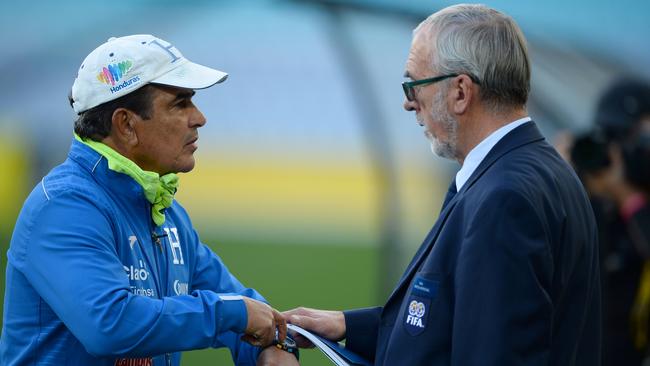 Honduras' national coach Jorge Luis Pinto (L) talks to a FIFA official about media coverage