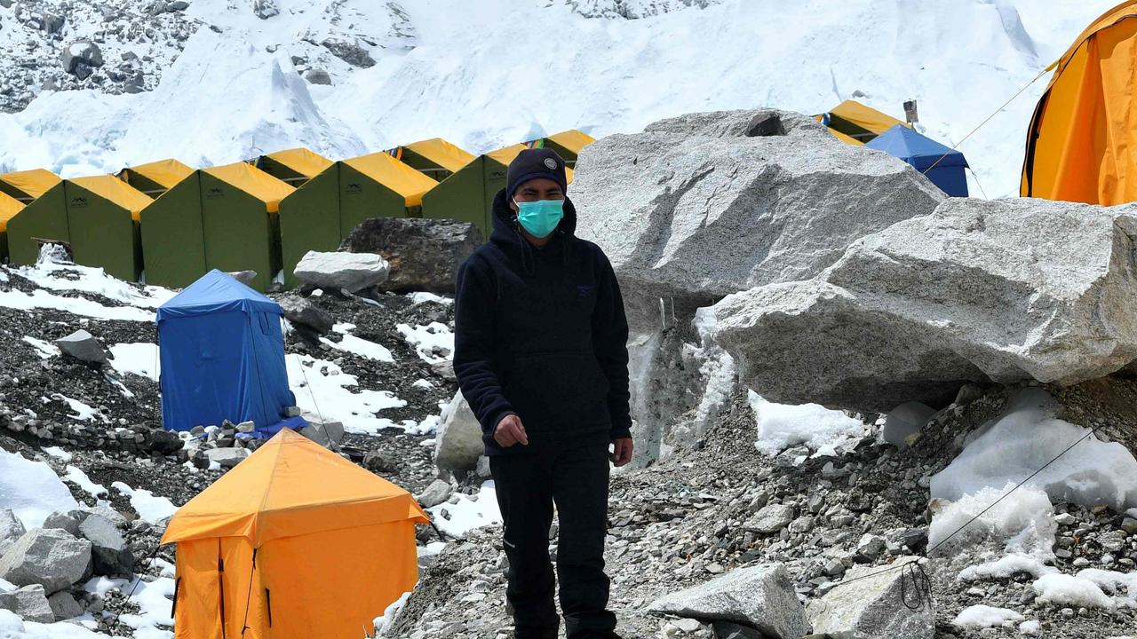 A expedition base camp staff wearing a face mask walks around Everest base camp where COVID-19 has now infiltrated. (Photo by PRAKASH MATHEMA / AFP).