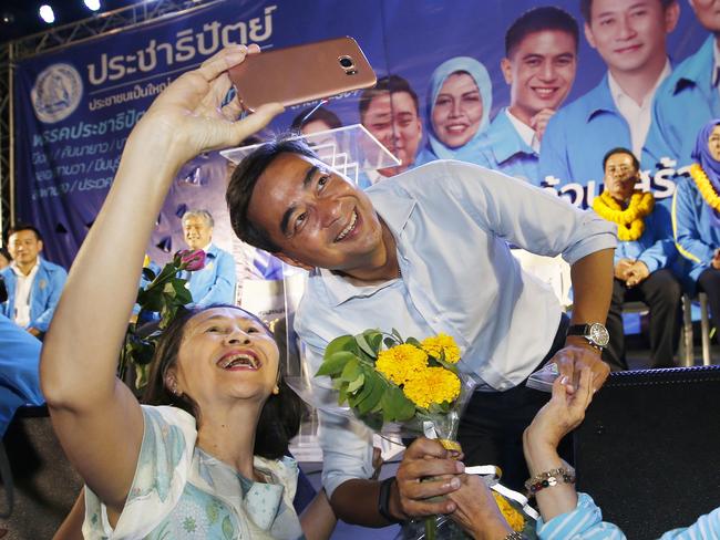 In this Monday, March 18, 2019. a supporter takes a selfie with the leader of Thailand's Democrat Party Abhisit Vejjajiva during an election campaign in Bangkok, Thailand. Abhisit says if he becomes prime minister after Sundayâ€™s election, heâ€™ll make careful but forceful efforts to undo undemocratic constitutional clauses imposed by the military government that took power in 2014. (AP Photo/Sakchai Lalit)