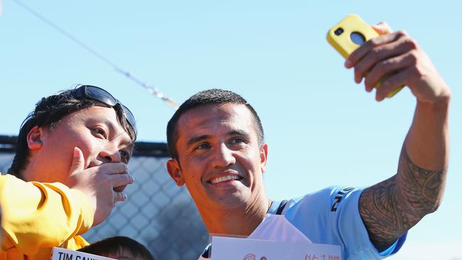 New signing Tim Cahill takes selfies with fans.