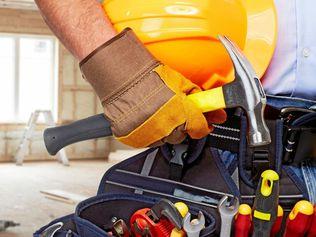 Builder handyman with construction tools. House renovation background.