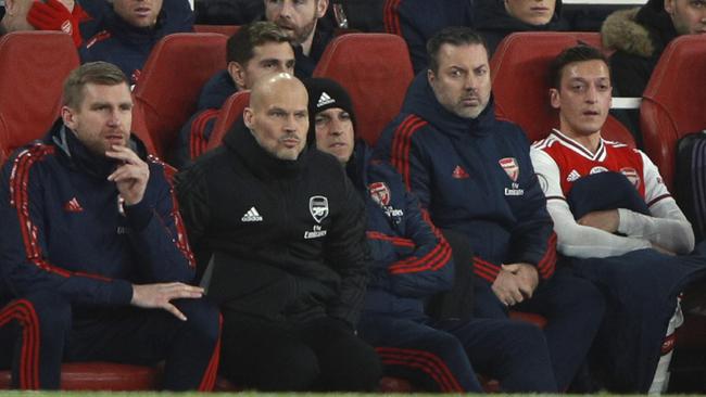 Arsenal's Mesut Ozil, right, and Arsenal's interim head coach Freddie Ljungberg sit on the bench during their side’s loss to Manchester City. Picture: AP