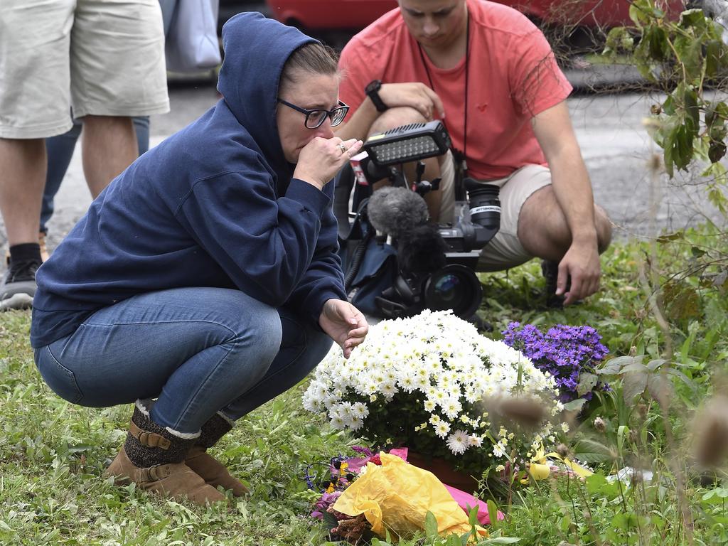 People place floral tributes at the scene. Picture: AP